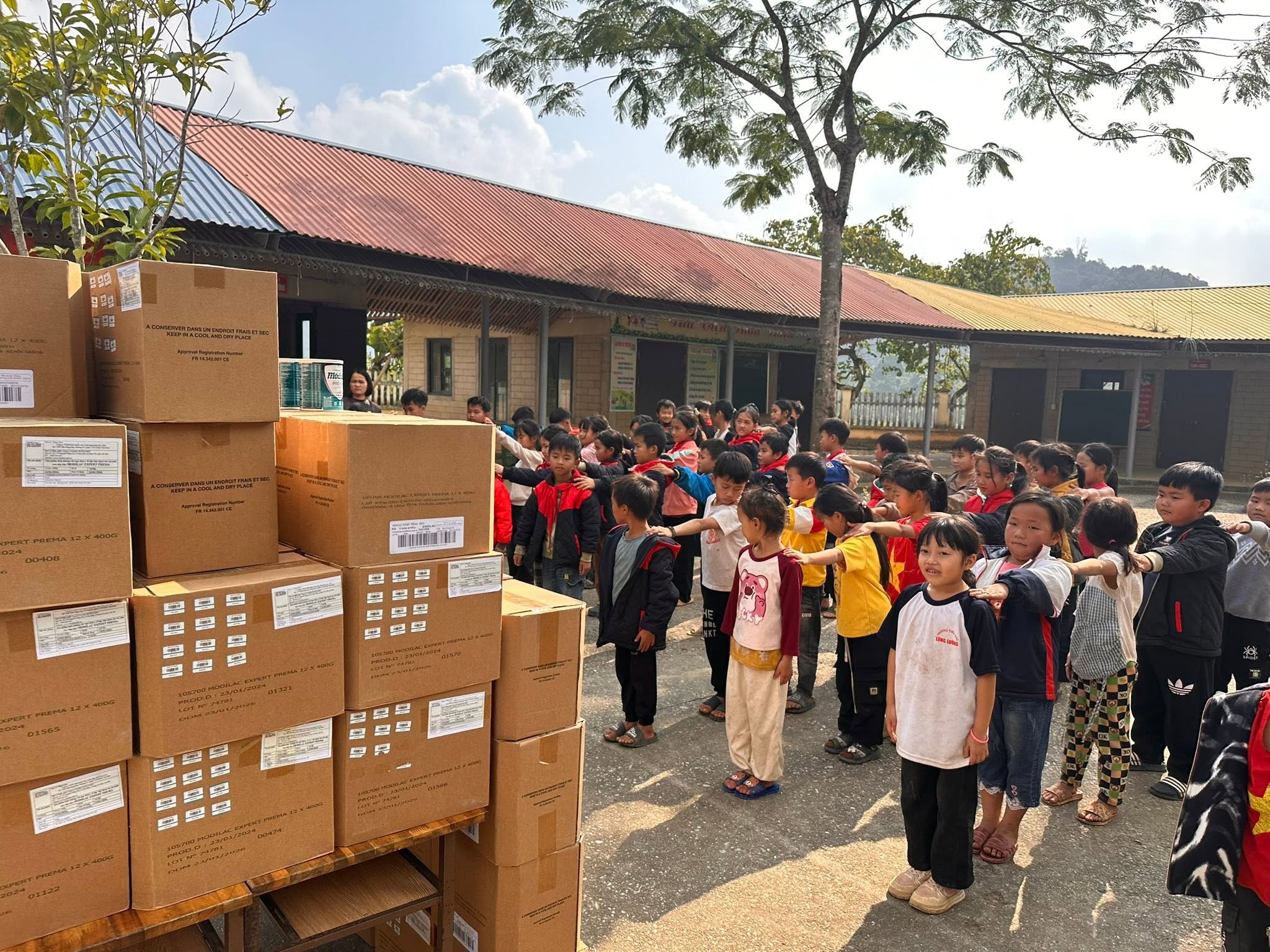 Thùng hàng được dỡ xuống sân trường. Phần lớn công việc của một chuyến đi nằm ở những phút như thế này — không